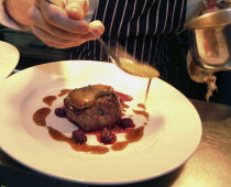Chef Plating Up Fillet Steak and Raspberry CoulisFood  cooking Great Britain UK United Kingdom British Isles Northern Europe