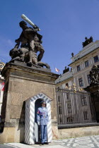 Sentry at guard box at the entrance to Prague Castle beneath a statue of fighting giants by Ignaz Platzer in HradcanyPraha Ceska Eastern Europe European