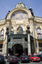 Parked cars and pedestrians outside The Art Nouveau Municipal House entrance in The Old Town with the mosaic by Karel Spillar titled Homage To Prague under the Hall domePraha Asian Ceska Eastern Euro...