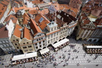 Rooftops and pavement restaurants with diners in the Old Town Square and pedestrians walking pastPraha Ceska Eastern Europe European
