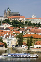 A cruise boat on the Vltava River passes the Little Quarter below St Vituss Cathedral and Prague Castle in HradcayPraha Ceska Eastern Europe European Religion