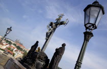 The 17th Century wooden Crucifiction on the Charles Bridge across the Vltava River with Prague Castle and St Vituss Cathedral beyond in HradcanyPraha Ceska Eastern Europe European Religion