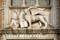 A stone carving of a Doge kneeling before the winged Lion of St Mark  the symbol of Venice  above the 15th Century Gothic Porta della Carta  the principal entrance to the Doges Palace