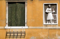 Carved stone wall plaque and window detail of a house in the Castello district