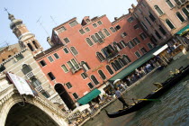 A gondola passes through the Rialto Bridge spanning the Grand Canal