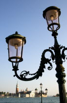 Ornate lamp post on the Molo San Marco with Palladios church of San Giorgio Maggiore on the island of the same name in the Venice Basin in the distance