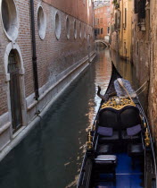 Empty gondola moored in a narrow canal in the San Marco district