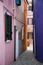 Brightly painted colourful houses in a narrow alley on the lagoon island of Burano