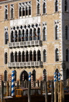 Ca Foscari on the Grand Canal built for Doge Francesco Foscari in 1437 with boat mooring wooden pillars in the foreground. Now part of the University of Venice