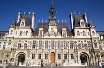 Tourists walk past the facade of the Hotel de Ville or Town HallEuropean French Western Europe
