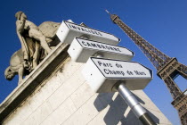 Statue of man and horse on a plinth at the entrance to the Pont DIenta bridge with roadsigns below and the Eiffel Tower beyondEquestrian European French Western Europe