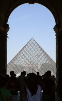 Tourist crowds pass through the entrance arch of the Sully wing of the Musee du Louvre towards the Pyramid entranceEuropean French Western Europe