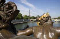 Bronze female figure on the Pont Alexandre III bridge across the River Seine below with the Eiffel Tower beyondEuropean French Western Europe