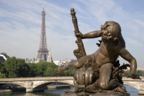Bronze cherub on the Pont Alexandre III bridge with the Eiffel Tower beyondEuropean French Western Europe