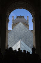 Tourist crowds walking through the Richelieu wing archway towards the Pyramid entrance to the Louvre MuseumEuropean French Western Europe