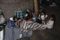 Young woman and children on pilgrimage to Chalma resting on roadside surrounded by belongings.