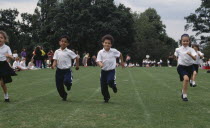 Five year olds taking part in running race during school sports day.European Great Britain Kids Learning Lessons Northern Europe Teaching UK United Kingdom