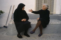Two elderly ladies in conversation in village street.Gestures and Emotions Andalusia Andalucia Espainia Espana Espanha Espanya European Southern Europe Spanish