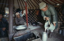 Badamtsetseg pouring milk for tea inside yurt.Ger Asia Asian Mongol Uls Mongolian
