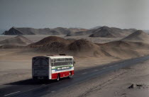 Bus on the Pan American highway through coastal desert connecting Ecuador and Chile.