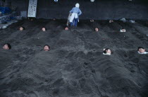 Hot Sand Bath. People submerged in sand with their heads pocking out above the surface.Asia Asian Japanese Nihon Nippon