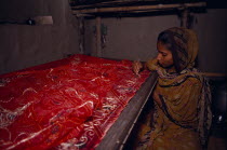 Sari maker Saida Begum working on red sari.Asia Asian Bharat Inde Indian Intiya  Asia Asian Bharat Inde Indian Intiya