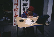 Child practising calligraphy at desk.Asia Asian Chinese Chungkuo Jhonggu Kids Zhonggu  Asia Asian Chinese Chungkuo Jhonggu Kids Zhonggu
