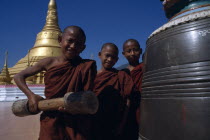 Young Burmese novice monks at Wat Phra That wao with golden stupa behind.Burma Asian Kids Myanma Myanmar Religion Southeast Asia Religious Burma Asian Kids Myanma Myanmar Religion Southeast Asia Rel...