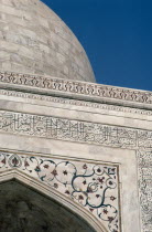 Detail of semi precious stones inlaid in white marble with Arabic script quoting from the Koran on the Taj Mahal