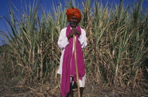 Full length portrait of man wearing pink scarf and red turban.Asia Asian Bharat Inde Indian Intiya  Asia Asian Bharat Inde Indian Intiya