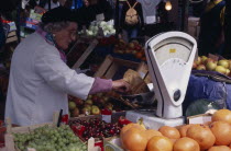 Portobello Road. Fruit market with women stall holder near a weighing scales