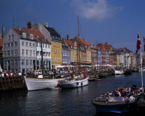 Nyhavn Harbour. Traditional waterfront buildings and tourists traveling along waterway on boatsDanish Danmark Northern Europe Scandinavia Travelling
