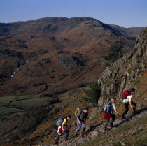 Walkers on footpath to Helm Crag above Grasmere with view west to Sour Milk Gill.European Great Britain Northern Europe UK United Kingdom British Isles Scenic