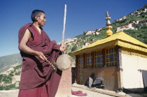 Monk calling other monks to prayer with a drum.
