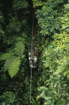 Tourists in aerial tram through rainforest near Braulio Carillo National Park.American Scenic