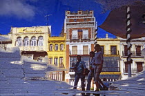 Reflection of buildings and pedestrians in Plaza de San Francisco.TravelTourismHolidayVacationExploreRecreationLeisureSightseeingTouristAttractionTourDestinationTripJourneySevilleSevil...
