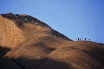 Kata Tjuta National Park  Mount Uluru  People climbing  Ayers Rock.TravelTourismHolidayVacationExploreRecreationLeisureSightseeingTouristAttractionTourDestinationMountUluruAyersAyresR...