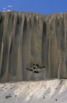 Cave dwellings cut into  organ pipe  shaped cliff formations near Yara village.erosion eroded home shelter abode Asia Asian Nepalese Scenic