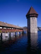 Kappelbrucke flower decked covered bridge spanning across The River Reuss. Part  view with Wasserturm 13th Century octagonal Tower European Schweiz Suisse Svizzera Swiss Western Europe Luzern History...