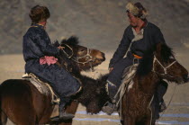 Kazakh nomads playing Bozkashi at Kazakh New Year festival.  Two riders holding headless animal carcass between them.Bokashi Asia Asian Mongol Uls Mongolian 2