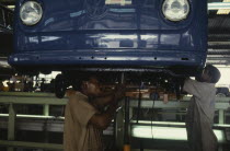 Men working on underside of car on Volkswagen car assembly line.Automobile African Automotive Automvil Cars Male Man Guy Motorcar Nigerian Western Africa Automobiles Autos Male Men Guy