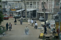 Street scene in the business district with people and traffic and criss crossing overhead cables.African Nigerian Western Africa
