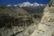 Mountain pass and steep sided gorge with snow capped mountain peaks in the distance.Asia Asian Nepalese Scenic