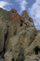 Cave monastery perched high on steep  eroded cliff face.Asia Asian Nepalese Religion Scenic Religious