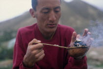 Tibetan lama preparing incense for puja or prayer ceremonyAsia Asian Nepalese Religion Religious One individual Solo Lone Solitary