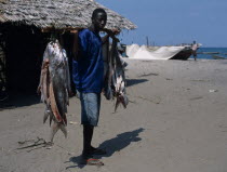 Fisherman standing on the beach with some of his days catchAfrican Beaches Eastern Africa Resort Sand Sandy Seaside Shore Tanzanian Tourism
