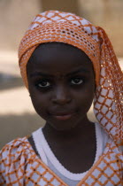 Portrait of girl wearing orange headscarfAfrican Nigerian Western Africa