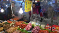 Namdaemun - Namdaemun market  December evening  food stall  women cooking  customers eating  stacks of meat and fish waiting to be cookedAsia Asian Classic Classical Daehanminguk Female Woman Girl La...