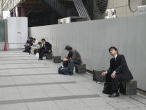 Tokyo Station  Nihonbashi entrance  morning commuters take a break outside before going to work  some smoke cigaretteAsia Asian Japanese Nihon Nippon Gray Grey