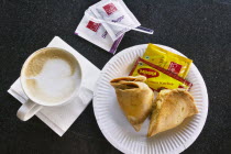 Cappuccino and samosas in a modern coffee shop.CoffeeCup FoodDiningIndianSnackTastyCappuccinoSamosa Asia Bharat Inde Intiya Store Asian